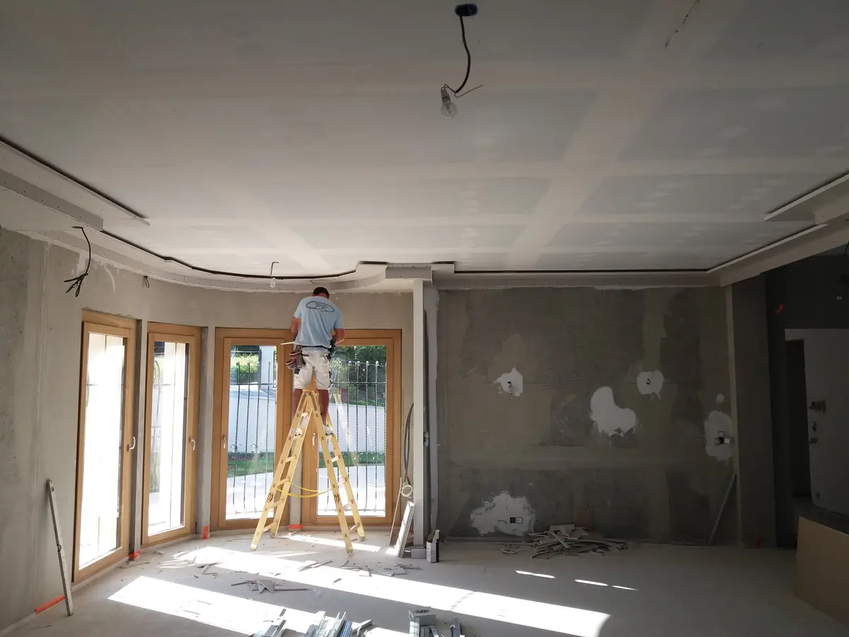Operaio Fontana Raffaele al lavoro su un controsoffitto in cartongesso in un soggiorno in costruzione