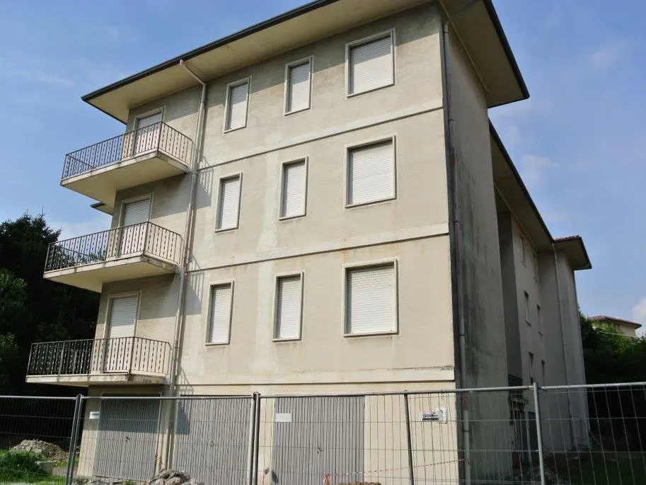 Facciata di un condominio prima del lavoro: intonaco ingrigito e macchiato